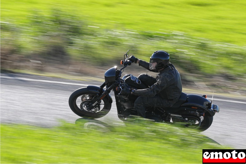 bras ecartes genoux remontes et buste legerement penche vers l avant au guidon de la low rider s